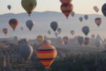 Hot air balloons flying over a mountainous landscape