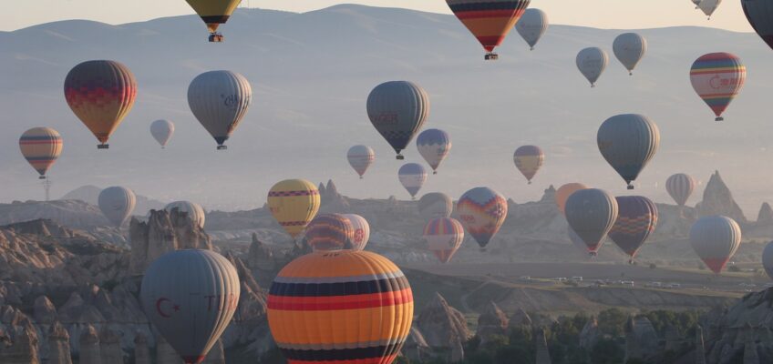 Hot air balloons flying over a mountainous landscape